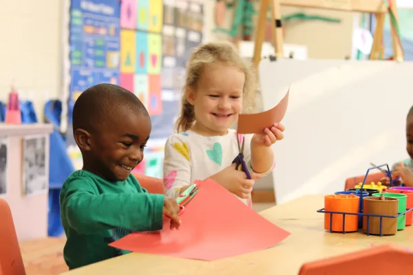 Two kids doing crafts in classroom