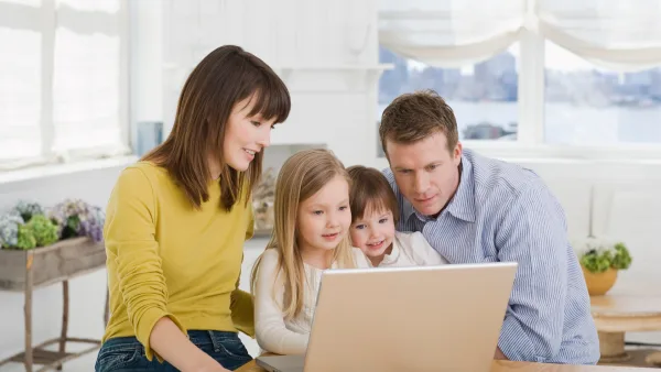 Two parents and two children looking at a computer screen