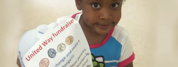Child holding flyer "United Way Fundraiser"