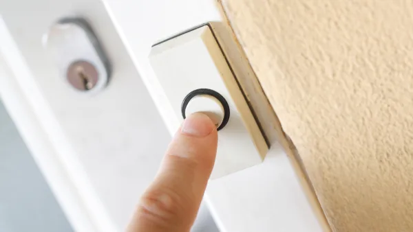 A finger pressing a doorbell